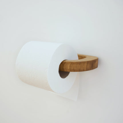 Samoprzylepny uchwyt na papier toaletowy z jasnego drewna, montowany bez wiercenia, idealny do nowoczesnej łazienki.