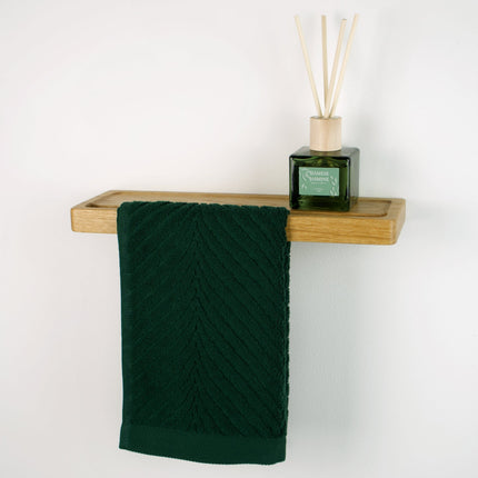 Mała dębowa półka z uchwytem na ręcznik do małej łazienki. Drewniany wieszak z półką ma biżuterię.