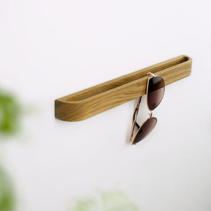 Designerski wieszak na okulary z naturalnego dębu, montaż bez wiercenia na gładkiej powierzchni ściany.