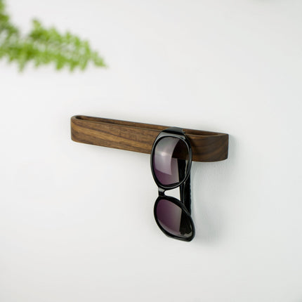 Zbliżenie na naturalne słoje drewna orzecha; uchwyt na okulary wykonany z jednego kawałka drewna, a nie ze sklejki.