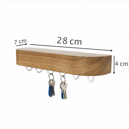 Zdjęcie dębowej półki na klucze z nałożonymi infografikami wymiarów: długość 28 cm, głębokość 7 cm i grubość 4 cm, ilustrując jej optymalne, kompaktowe proporcje.