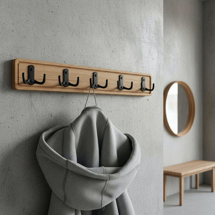 Widok z boku na dębowy wieszak, pokazujący elegancki profil frezowanej deski i odstęp haczyków od ściany.
