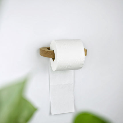 Nowoczesny, minimalistyczny uchwyt na papier toaletowy wykonany z jednego kawałka litego drewna dębowego o pięknym rysunku słojów.
