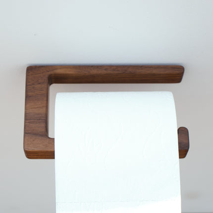 Minimalistyczny wieszak łazienkowy z litego drewna orzechowego montowany na mocną taśmę bez wiercenia.