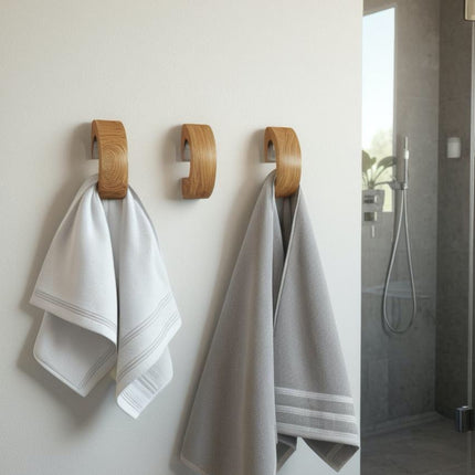 Dębowy wieszak punktowy w stylu skandynawskim zamontowany w łazience. Naturalne drewno dębowe dodaje ciepła nowoczesnemu, surowemu wnętrzu.